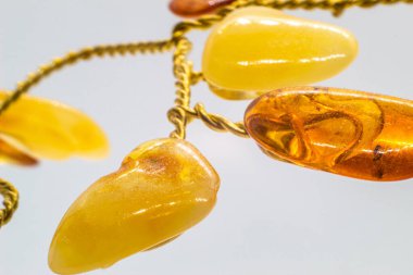 Canlı sarı ve turuncu cilalı kehribar kristal ve bakır tel ağaç beyaz yüzeyde izole edilmiş mavi kalsiyum mineral bazlı makro.