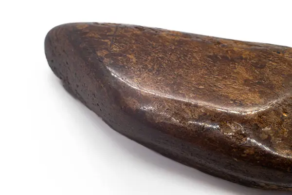 Macro Focused Tumbled Dark brown and shiny bronze bronzite stone polished crystal isolated on a white surface background 