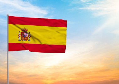 Bir bayrak direğine uzanan 3 boyutlu bir İspanya bayrağı ve arka planda gün batımlı güzel bir gökyüzü.