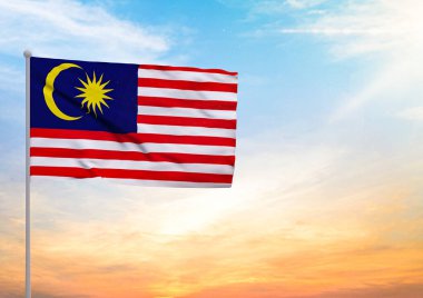 Bir bayrak direğine uzanan Malezya bayrağının 3 boyutlu çizimi ve arka planda gün batımlı güzel bir gökyüzü