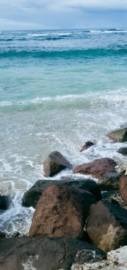 Kaya portresi ve kumsaldaki mavi gökyüzü.