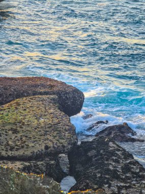 Denizde güçlü ve dayanıklı kayaların güzel sanat resimleri.