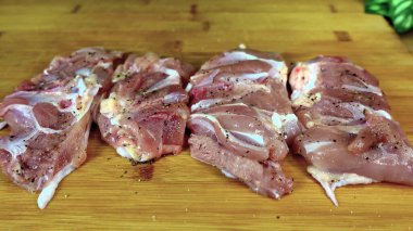 Fresh chicken meat in spices and with pepper on a wooden board.