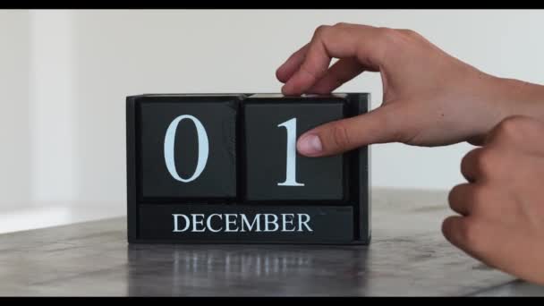 冬の月2 12月 男性の手は大理石のテーブルの上で白い背景に立方永久カレンダーをオンにします — ストック動画