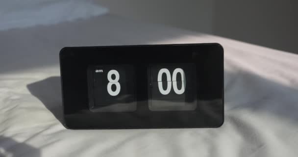 現代のデジタル目覚まし時計は午前8時に寝室で鳴り 白い背景に日光が降り注いでいます アラームタイマーは8時位置に設定します 目を覚ますと仕事に行く時間です 朝のコンセプト — ストック動画