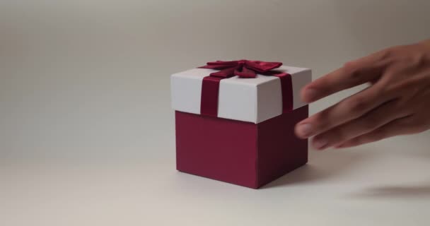 Close Uma Caixa Presente Com Arco Amarrado Vermelho Mãos Humanas — Vídeo de Stock