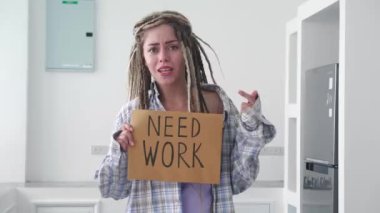 Rastalı işsiz hippi bir kadın, elinde karton bir poster, iş arıyor, iş teklifini kabul ediyor.