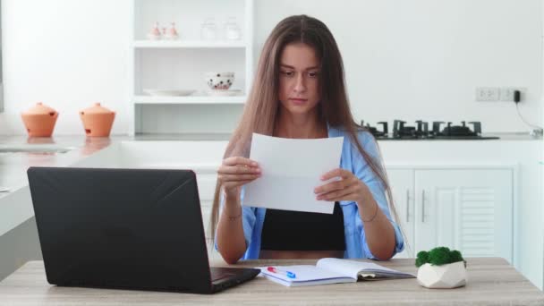 Ładna Kobieta Siedząca Przy Stole Laptopem Trzymająca Kartkę Papieru Pracująca — Wideo stockowe