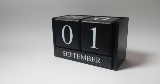 閉じた男性の手は9月の日付を変更し 黒の木製の立方永久カレンダー上の数字で立方体を回します — ストック動画