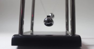 Yakın plan. Kromatik küreleri sallanan ve yavaşlayan Newton toplarının ön görüntüsü. Kinetik sarkacı. Hareket. Eylemsizlik