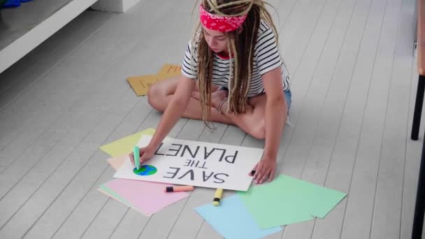 顶级的志愿嬉皮士女性 一个活动者画了一张海报 上面的信息拯救了地球 环境运动 — 图库视频影像
