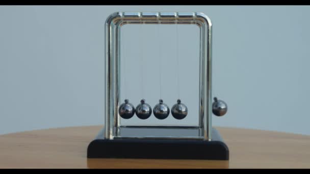 牛顿球与摆动的金属球的闭合 在热带自然背景下的窗台上 — 图库视频影像