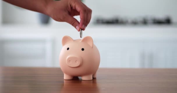 Mans Mão Colocando Moedas Porquinho Banco Forma Porco Fundo Branco — Vídeo de Stock