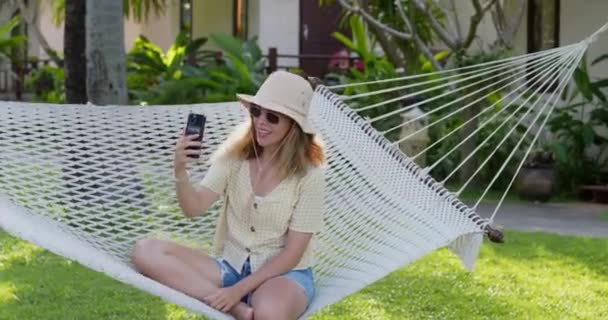 Chica Sonriente Tiene Conversación Vídeo Con Amigos Usando Auriculares Teléfono — Vídeo de stock