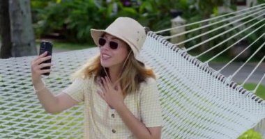 Genç bir kadın kendini kaldırıyor ve terasta bir şekerleme yaptıktan sonra uyanıyor. Ekin görünümü.