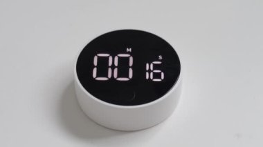 digital clock lies isolates on white background Digital clock with black screen and white LED backlight counts down the time. digital clock