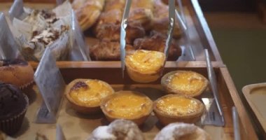 Tanınmayan kişi paslanmaz çelikten mutfak tokasıyla bir yumurtalı tartı alır ve tepsiye koyar. Taze pasta iştah açıcı yumurtalı tart ve nefis kahvaltı kavramı yumurtalı tart.