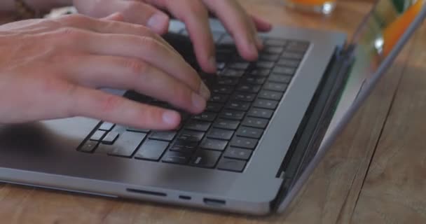 男人在键盘上打字坐在室内咖啡店或客厅侧看忙碌的男人在笔记本电脑上打字男人无法辨认的打字文字 — 图库视频影像