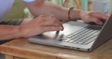 Klavyeye yazı yazan erkek eli kapalı kafe ya da oturma odası yan görüntüsü Laptop erkeği tanımlanamayan yazıcı saldırısına metin yazmakla meşgul.