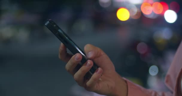 女人的手在夜城街上输入短信 智能手机或使用应用程序 连接和搜索社交网络 模糊的背景和错误的影响 使用应用程序的手持特写拍摄概念 — 图库视频影像