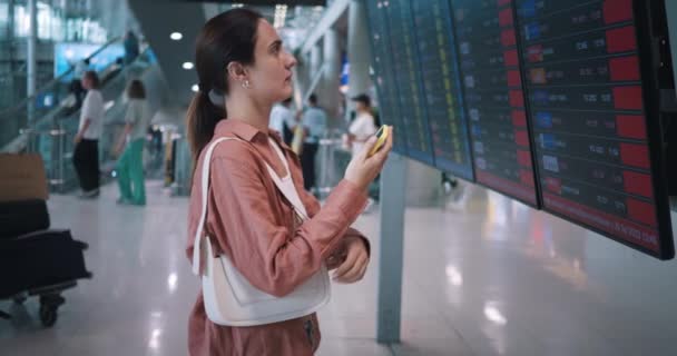 Femeia Din Terminalul Aeroportului Stând Fața Tabloului Bord Companiei Aeriene — Videoclip de stoc