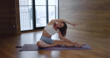 Evde ya da stüdyoda yoga esneme egzersizi yapan bir kadının sinematik hikaye anlatma videosu. Sağlıklı yaşam tarzının temsiliyeti spor faaliyetlerini genişletiyor. Paspaslı kadın esneme hareketleri yapıyor..