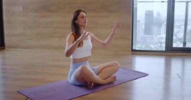 Genç akıl hocası meditasyon kadını stüdyoda lotus pozisyonunda oturur ya da meditasyon yapar. Genç meditasyoncu kadın esneme odasında ruhani uygulamalar yapıyor. Yoga sınıfındaki akıl hocası kadın çakra soluyor.