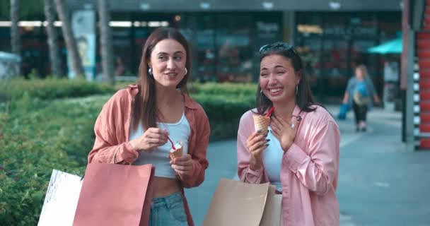 女人在户外吃冰淇淋时 会表现出生动的情绪 愉快的冰淇淋会引起笑声 愉快的冰淇淋象征着美味的欢乐 快乐的友谊 共同庆祝甜蜜的时刻 — 图库视频影像