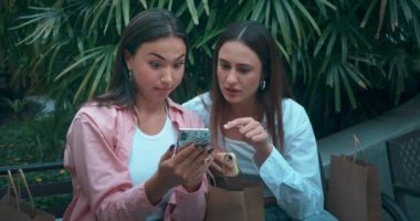 İki genç kadın bankta oturmuş telefonla sohbet ediyor. Yakın çekim şok deneyimi yaşıyorlar. Şaşırtıcı haberlerin şoku, kahkahalar, şok dostluk beklenmedik dönüşleri yansıtır.