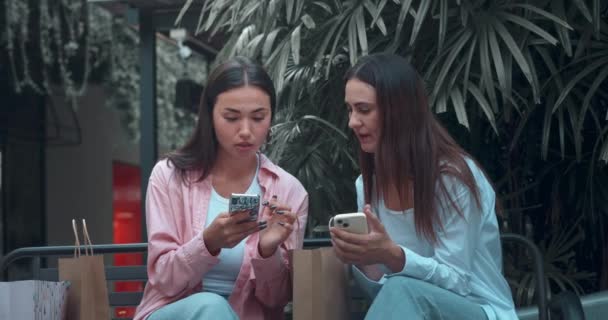 Γυναίκες Φίλοι Στον Πάγκο Επικοινωνούν Χρησιμοποιώντας Τηλέφωνα Που Αντικατοπτρίζουν Ειλικρινή — Αρχείο Βίντεο
