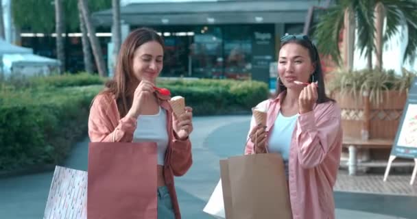 市街地の女性は アイスクリームをシェアし 幸せのための活発な感情アイスクリーム触媒を味わいます おいしい瞬間の陽気な友情のアイスクリームエッセンス — ストック動画