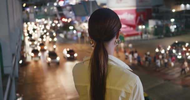 在大都市 妇女看着夜晚繁忙的交通 可以看到城市的交通脉动 无休止活动的交通流量说明城市生活的无休止性质 — 图库视频影像