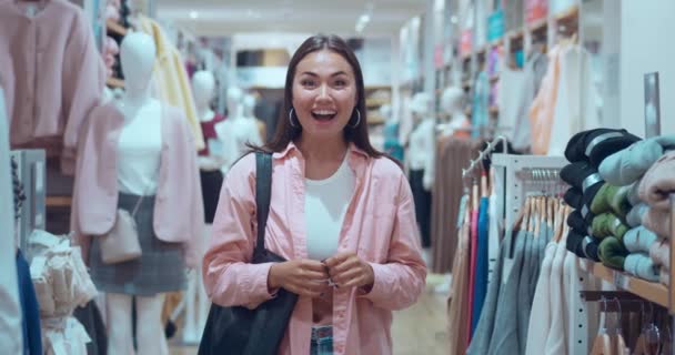 여성은 카메라에서 옷가게에서 행복으로 행복은 즐거운 쇼핑의 본질을 빛납니다 진심으로 — 비디오
