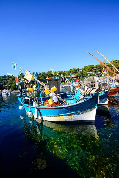 Niel 'in berrak sularında, kusursuz bir gökyüzünün altında demirlemiş mavi bir balıkçı teknesi.