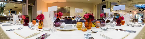 panorama of a dressed table for a wedding party with flowers and roses