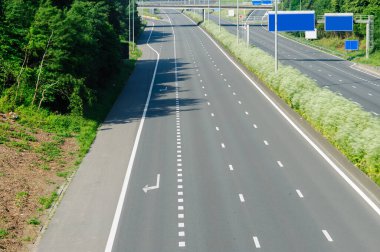 Canlı yeşilliklerle çevrili boş, bakımlı bir otoyol, ulaşım altyapısının güzelliğini ve çevrenin sükunetini yakalıyor..