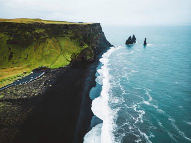 Reynisdrangar manzaralı volkanik kara kum plajı. Dalgalar siyah kumsala çarpıyor. Vik, İzlanda. Yüksek kalite fotoğraf