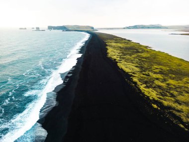 Reynisdrangar manzaralı volkanik kara kum plajı. Dalgalar siyah kumsala çarpıyor. Vik, İzlanda. Yüksek kalite fotoğraf