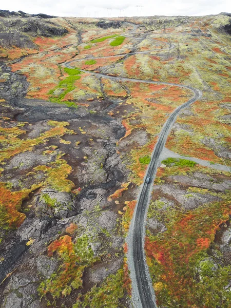 アイスランドの高地 F道路 川を渡る 緑の茂みと火山の土地に囲まれたアイスランド本土のどこかに離れた未舗装の道路 砂利道を一人で運転する車 — ストック写真