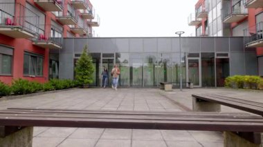 Bir grup arkadaş, öğrenci yurdunun önünde bulutlu bir sonbahar gününde genç beyaz kız öğrenciler okul için bir grup projesi hakkında konuşuyorlar.. 