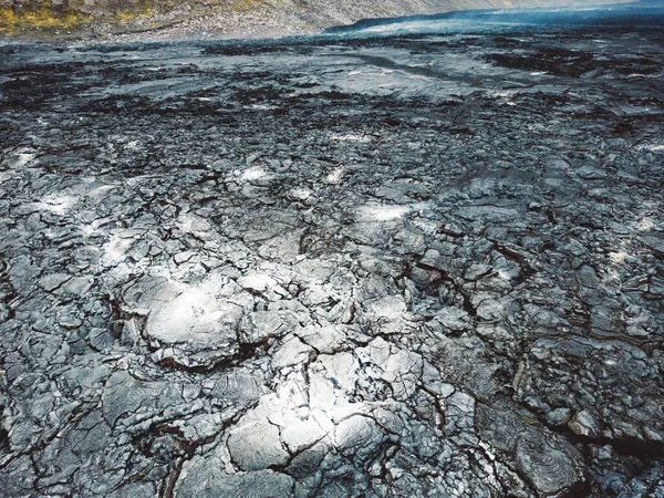 Geldingadalir active Volcano, errupting in 2021 - Fagradalsfjall and 2022 -Meradalir. Still hot lava rocks, steam comping up from the grounds. Dark grey, black volcanic rocks in Iceland. Dramatic view