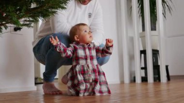 Kırmızı elbiseli şirin bir kız çocuğu Noel ağacına uzanmaya çalışıyor ve babası ona izin vermiyor.. 