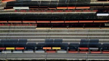 Kargo trenleri yakın plan. Tren istasyonundaki renkli yük trenlerinin hava manzarası. Demiryolunda malları olan vagonlar. Ağır endüstri. Trenli endüstriyel kavramsal sahne. Uçan İHA 'nın üst görüntüsü