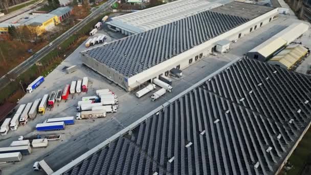 工業ビルの太陽光パネルの空中ビュー 太陽光パネルで屋根の上に覆われた工業地帯を飛んで ビューのドローンポイント — ストック動画