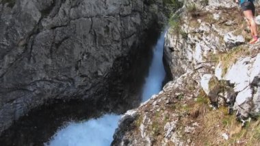 Slovenya 'da bir yerde ormanda saklı bir şelale. Kayalıklardan akan bir dere, köpüren bir su. Ormandaki yemyeşil yapraklar. Bakış açısı. Süre. 