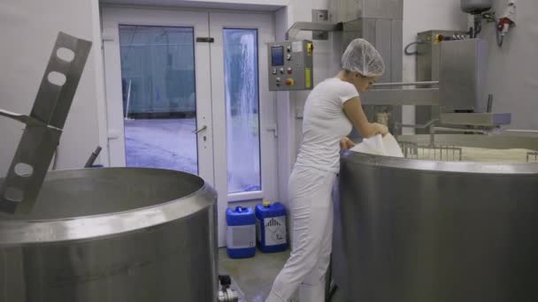 製造ラインの酪農場で働く白人女性 包装製品 牛乳を混合する機械で動作し チーズカードを作る 白地の制服を着た乳業労働者 — ストック動画