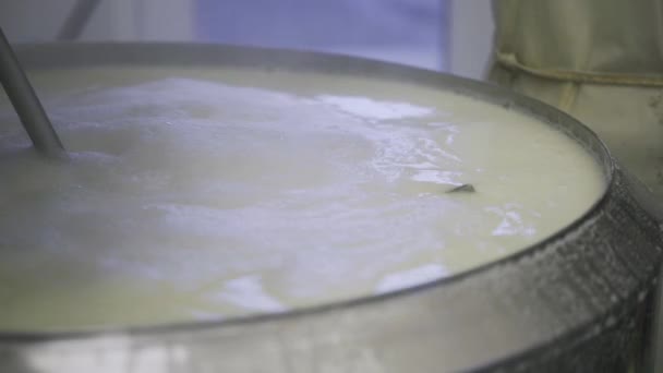 在乳品厂的一个大金属罐里 把热气腾腾的牛奶搅拌好 而不知名的工人关上瓶盖 — 图库视频影像