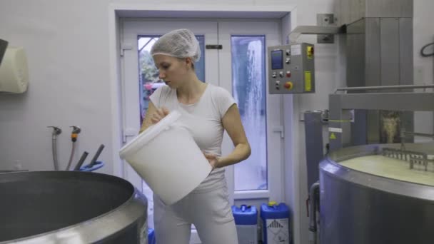 白人妇女在生产线上的奶牛场工作 包装产品 用机器搅拌牛奶 制作奶酪凝块 奶牛场工人全穿白色制服 — 图库视频影像