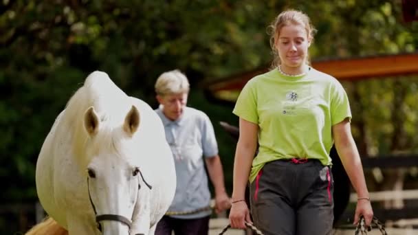 Pelatih Wanita Mengambil Kuda Untuk Naik Wanita Dengan Kemeja Hijau — Stok Video