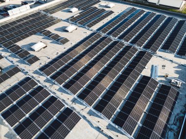 Endüstriyel binalardaki güneş panellerinin hava görüntüsü. İnsansız hava aracı bakış açısı, sanayi bölgesinde uçmak, çatıları güneş panelleriyle kaplı..